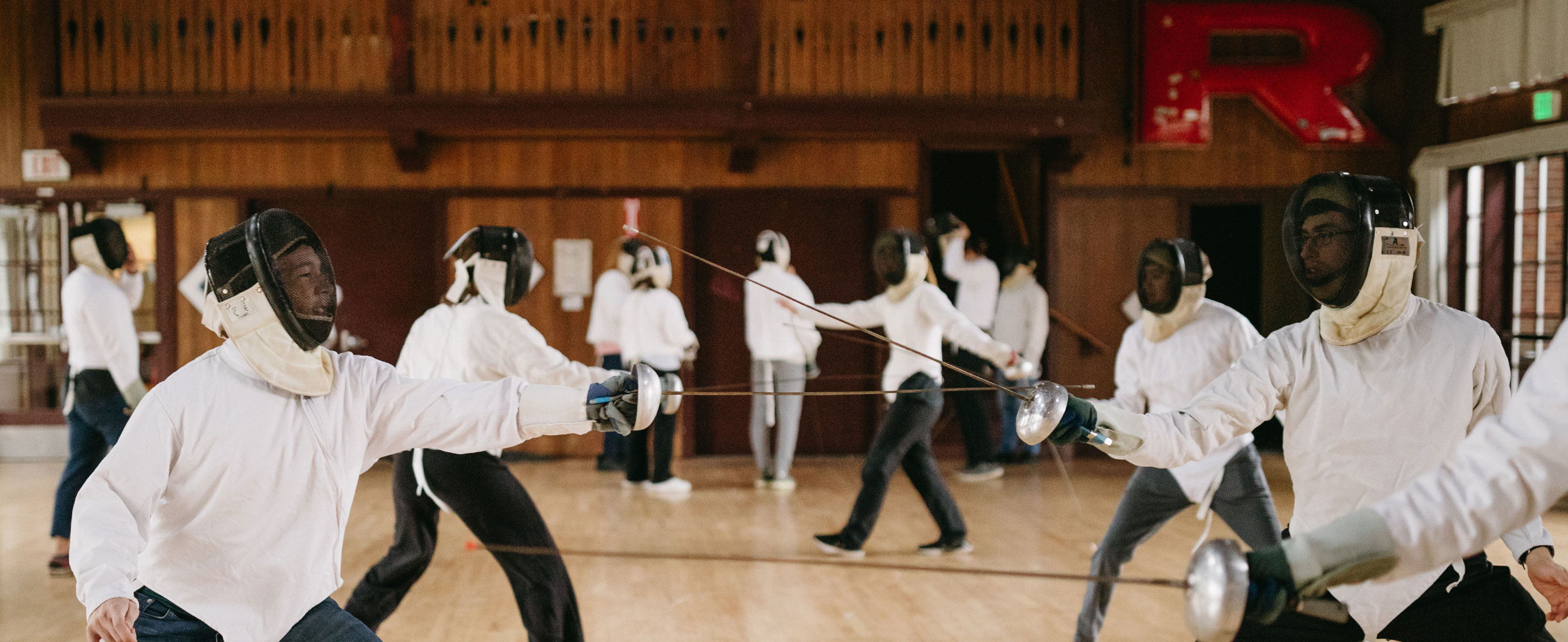 Reed students dressed in fencing gear practice fencing in a Paideia class.
