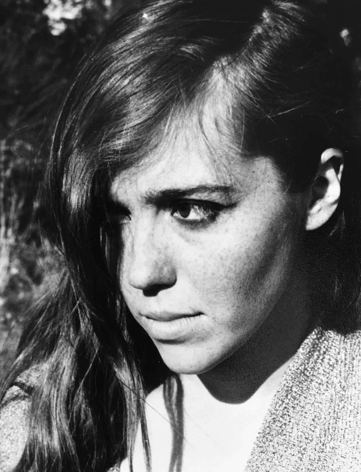 Katherine Dunn, in black and white, looking down with hair covering her right eye, during her time at Reed.