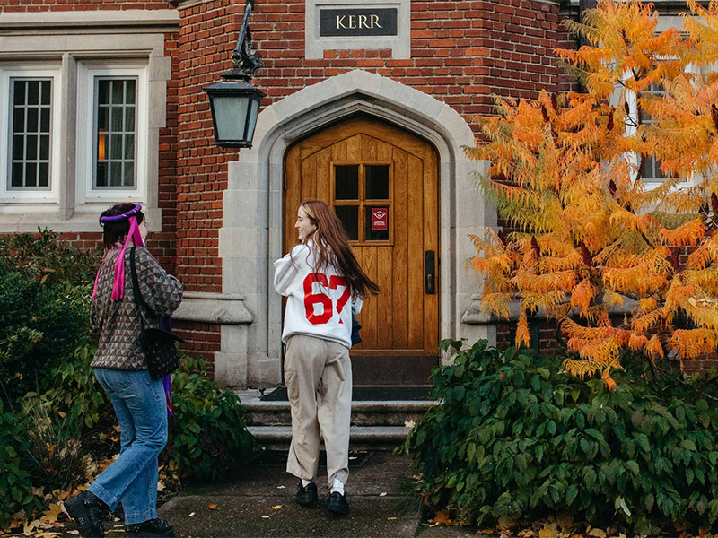 Two students entering Old Dorm block from the Kerr entrance.